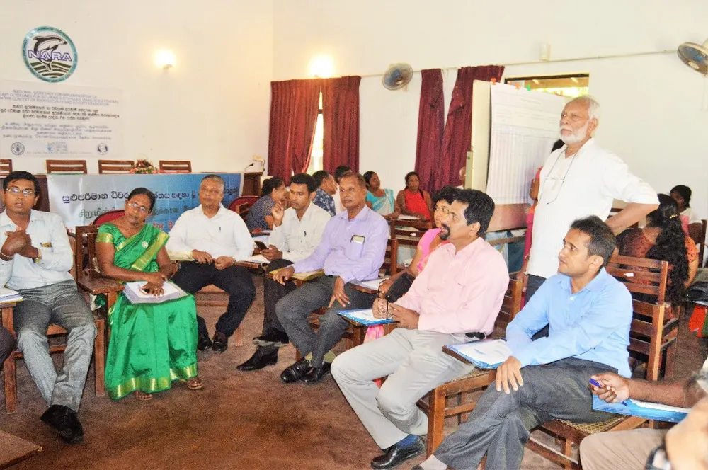 State officers, researchers and community members in discussion at Rekawa