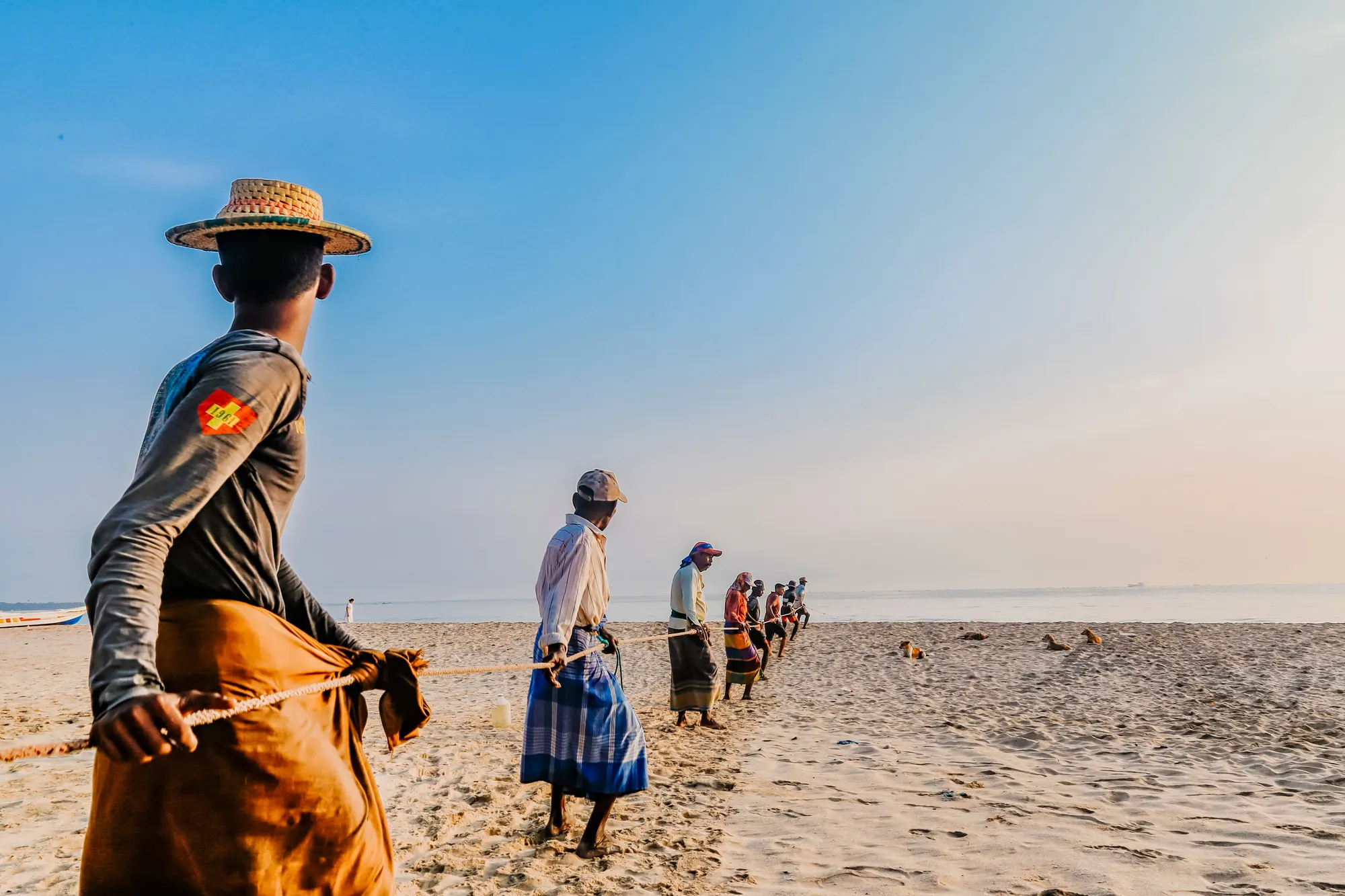 A fisher carrying a net along a beach in Sri Lanka