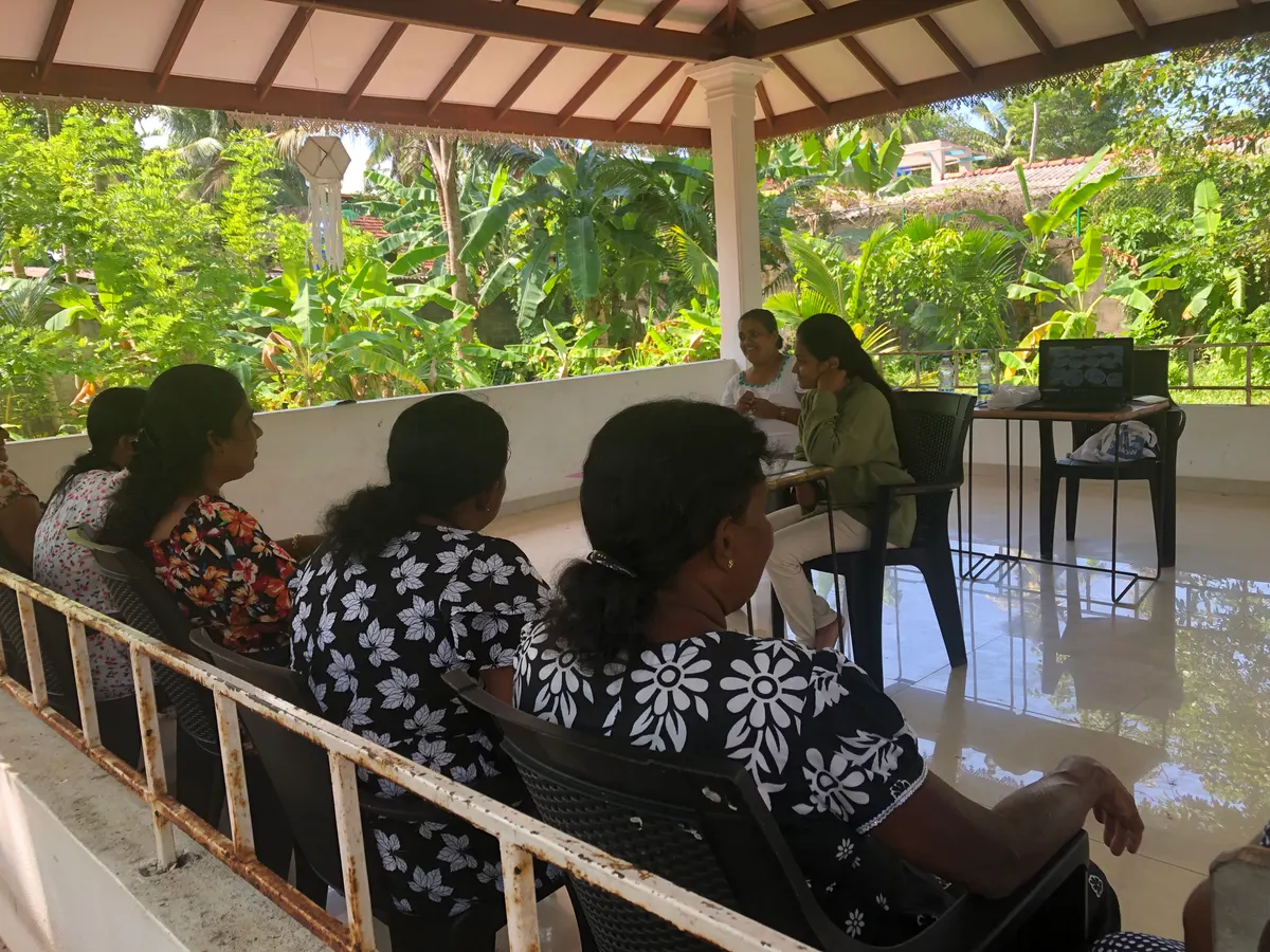 Women seated in a meeting hall listening to a presentation